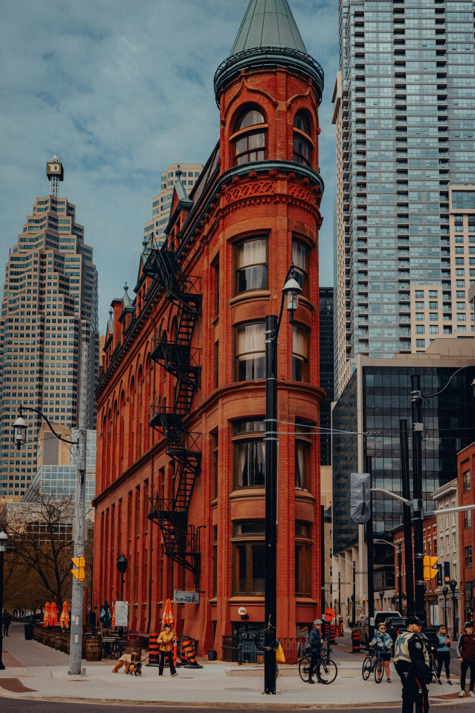 Capture of the iconic Gooderham Building in Toronto's bustling cityscape with a modern architectural backdrop.